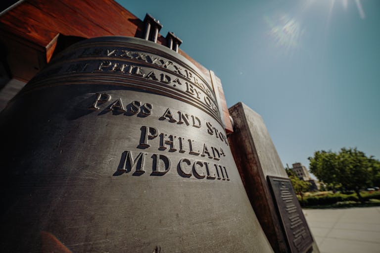A detailed view of the Liberty Bell in Philadelphia against a clear, sunny sky.